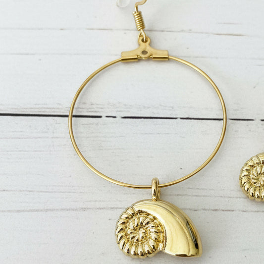 Gold hoop earring with a polished shell-shaped pendant,