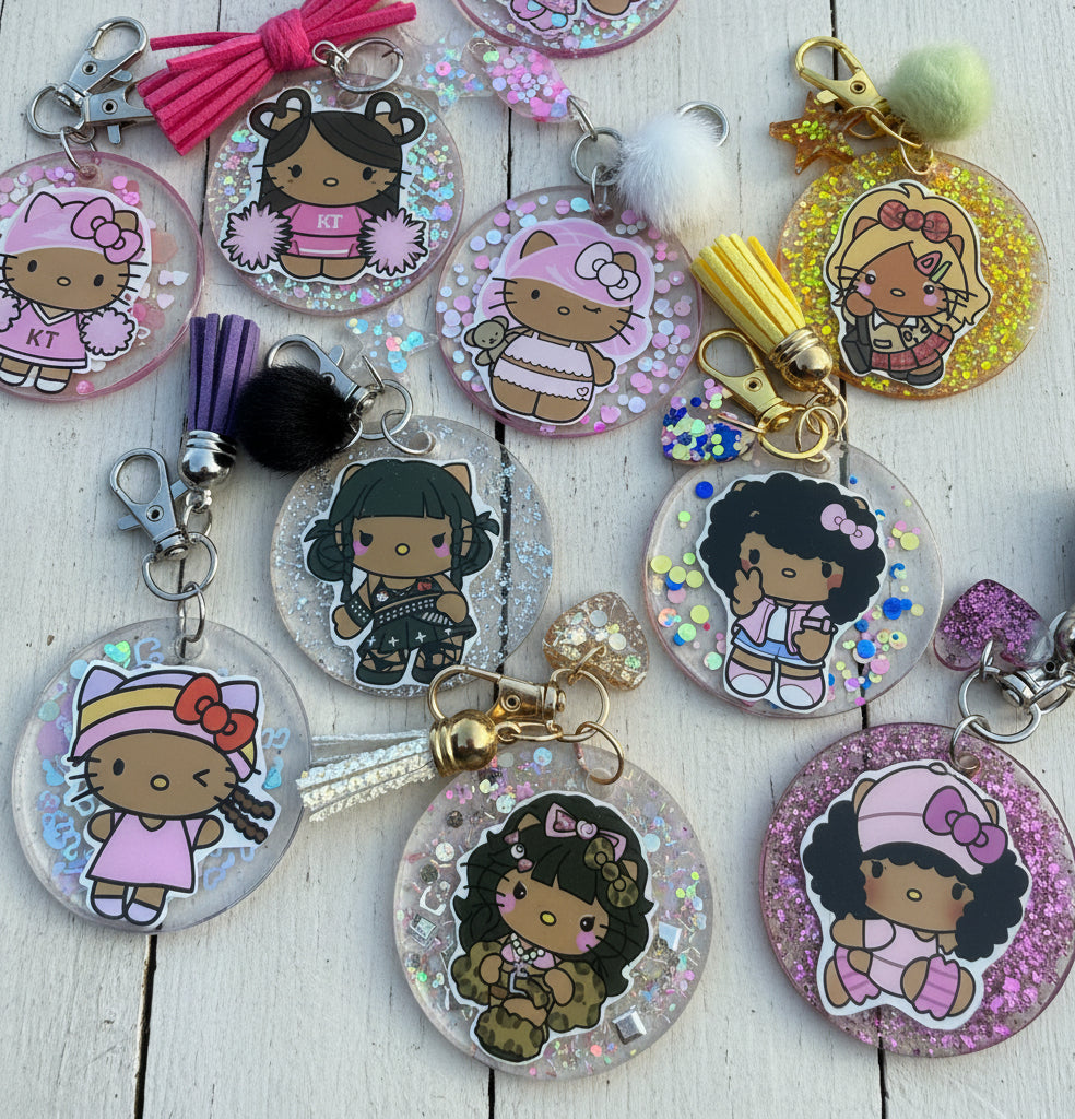 A group of round acrylic keychains featuring cartoon girl illustrations, some with glitter backgrounds and tassel charms, arranged on a white surface.
